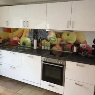 Küchenzeile mit Backofen und Fruchtmotiv an der Rückwand