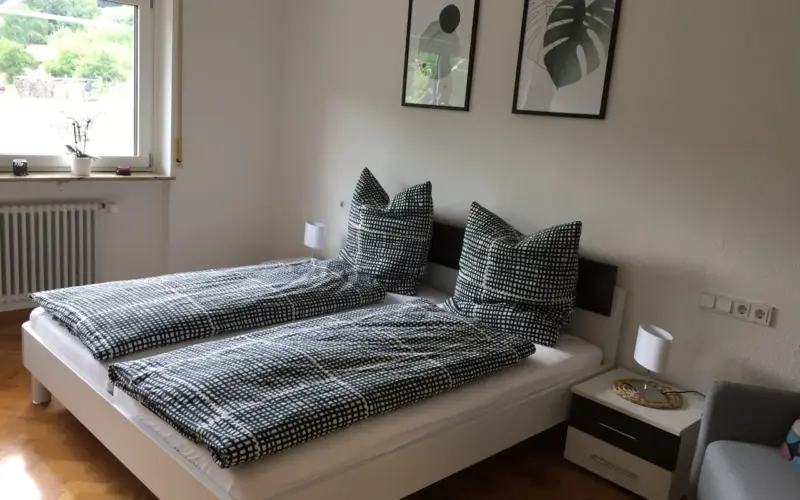 Schlafzimmer mit Doppelbett und Bildern an der Wand