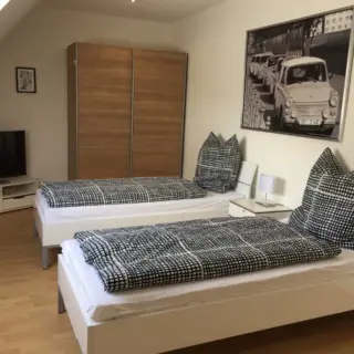 Zimmer mit zwei Einzelbetten, Schrank und Fernseher