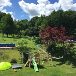 Garten mit Rasen, Spielturm mit Rutsche und Hängematte