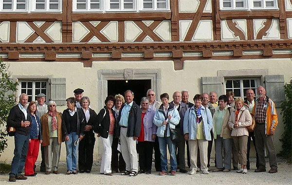 Gruppe von Personen vor einem Fachwerkgebäude mit Steinportal