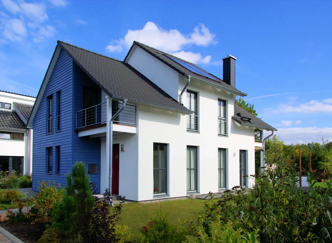 Modernes Wohnhaus mit blauer und weißer Fassade und Garten