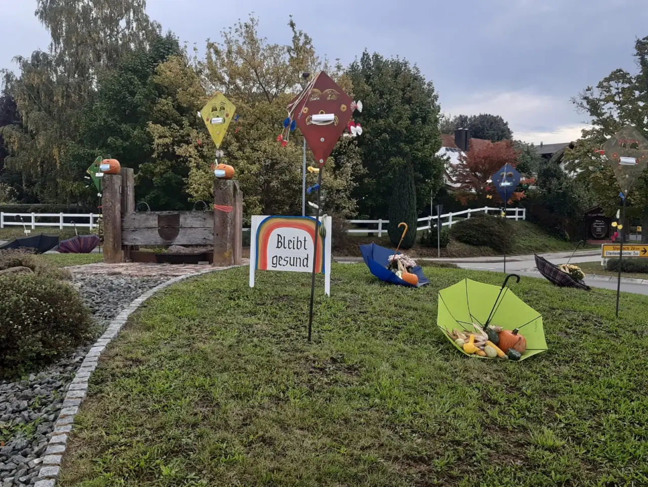 Kreisverkehr mit herbstlicher Dekoration und aufgespannten Schirmen