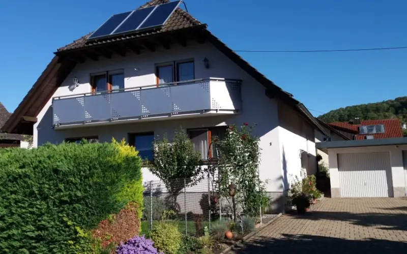 Wohnhaus mit Balkon und Solarmodulen auf dem Dach