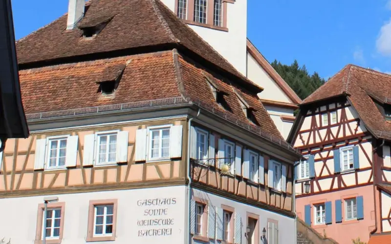 Gasthaus Sonne: Eckgebäude mit Walmdach neben der Kirche und Fachwerkhäusern