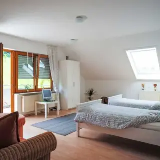 Dachgeschosszimmer mit zwei Betten, Sofa und Dachfenster