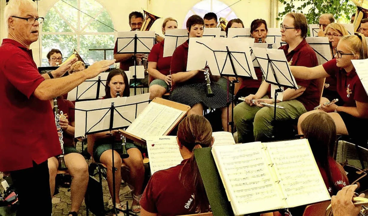 Musikverein beim Spielen unter einem Zelt, im Vordergrund Notenblätter
