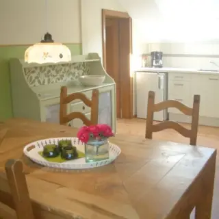 Wohnküche mit Holztisch, Stühlen und Küchenzeile