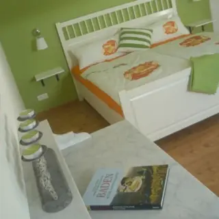 Schlafzimmer mit Doppelbett und grün gestrichenen Wänden