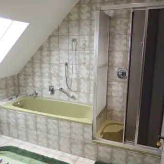 Badezimmer mit Badewanne, Dusche und Dachfenster