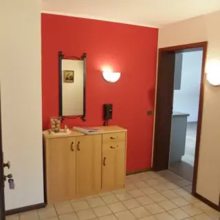 Flur mit roter Wand, Kommode und Spiegel