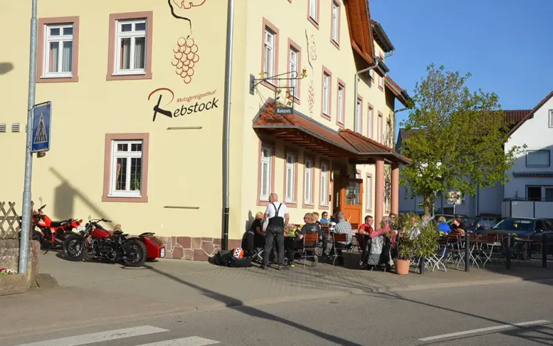 Metzgereigasthaus Rebstock mit Außenbestuhlung, davor parken Motorräder