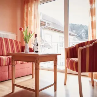 Sitzecke mit Sofa und Sessel vor einer Balkontür