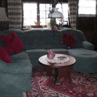 Wohnzimmer mit blaugrauem Sofa und rundem Tisch