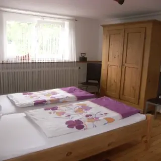 Schlafzimmer mit zwei Betten und einem Holzschrank